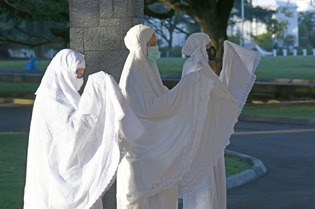 Jokowi mengenakan kemeja putih lengan panjang, sarung biru dan kopiah hitam sedangkan Ibu Negara Iriana Joko Widodo mengenakan mukena putih. Keduanya pun mengenakan masker. Hadir juga putera bungsu mereka Kaesang Pangarep yang mengenakan kemeja putih lengan panjang, sarung batik, dan kopiah hitam serta tak lupa masker hitam.