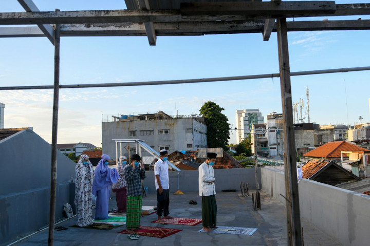 Sejumlah warga perantau yang tinggal di Gang Kelinci, Pasar Baru, Jakarta Pusat, melaksanakan Salat Idulfitri 1441 Hijriyah di teras atap rumah (roof top) pada Minggu, 24 Mei 2020.