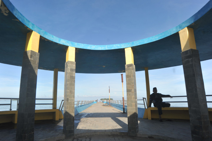 Warga duduk di Dermaga Pantai Gandoriah yang sepi di Pariaman, Sumatera Barat, Senin, 25 Mei 2020. ANTARA Foto/Iggoy el Fitra
