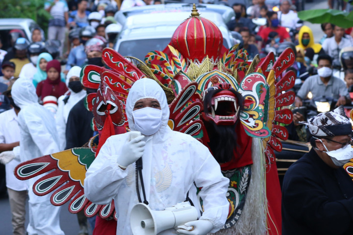 Barong diarak keliling kampung didampingi petugas kesehatan pada ritual adat Barong Ider Bumi di Desa Adat Kemiren, Banyuwangi, Jawa Timur.
