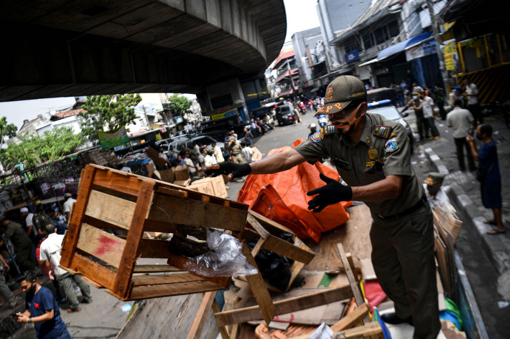 Anggota Satpol PP mengangkut barang-barang milik pedagang yang berjualan di kolong jembatan layang Pasar Pagi Asemka, Jakarta Barat.