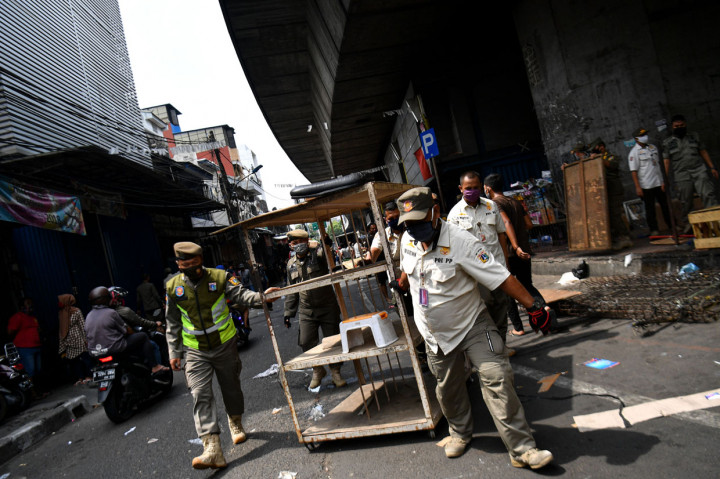 Anggota Satpol PP membawa etalase saat penertiban lapak pedagang di kolong jembatan layang Pasar Pagi Asemka, Jakarta Barat.