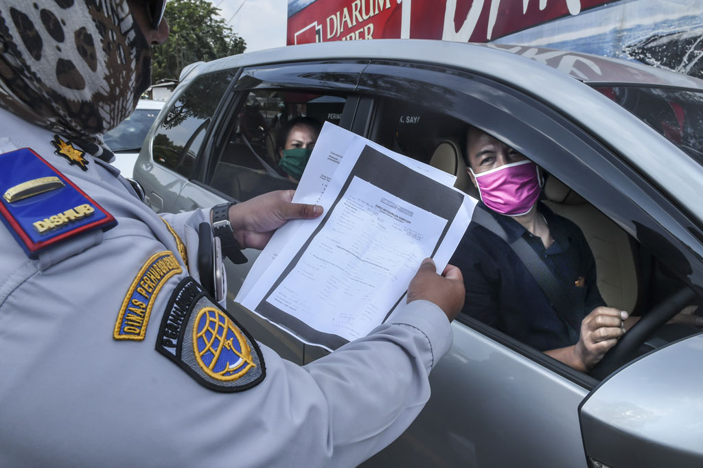 Petugas Dinas Perhubungan (Dishub) melakukan pemeriksaan terhadap pengguna kendaraan yang akan masuk ke wilayah DKI Jakarta di kawasan perbatasan Bekasi-Karawang, Jawa Barat, Jumat, 29 Mei 2020.