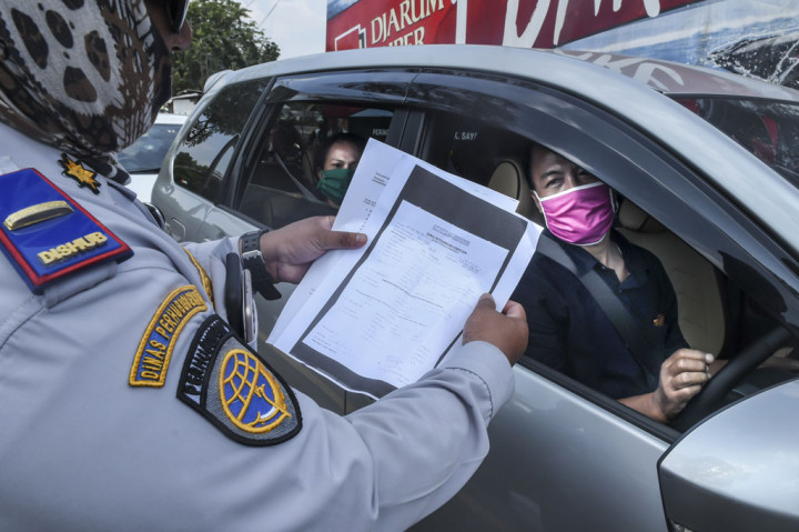 Petugas Dinas Perhubungan (Dishub) melakukan pemeriksaan terhadap pengguna kendaraan yang akan masuk ke wilayah DKI Jakarta di kawasan perbatasan Bekasi-Karawang, Jawa Barat, Jumat, 29 Mei 2020.