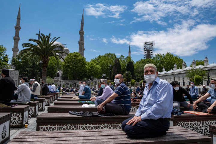 Ratusan jamaah yang mengenakan masker tampak melakukan salat di luar Masjid Biru Istanbul. AFP Photo/Yasin Akgul