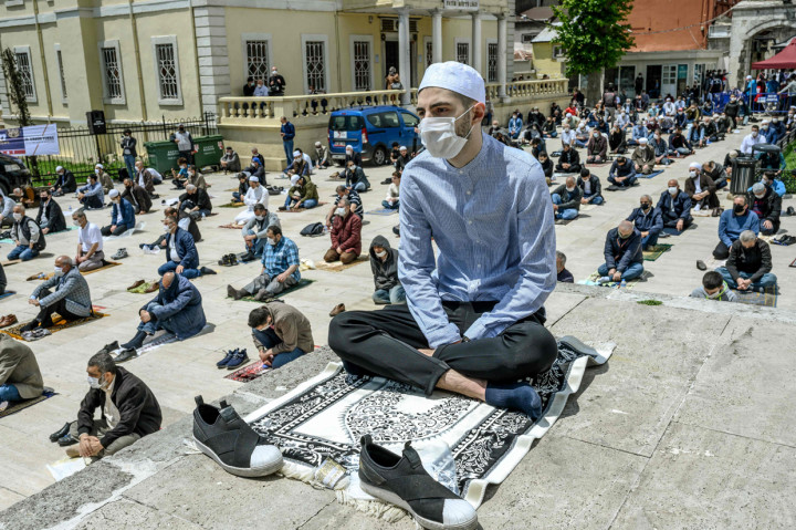 Di masjid Fatih, para jamaah salat di dalam dan di luar. Pemerintah setempat membagikan disinfektan dan sajadah sekali pakai. AFP Photo/Bulent Kilic