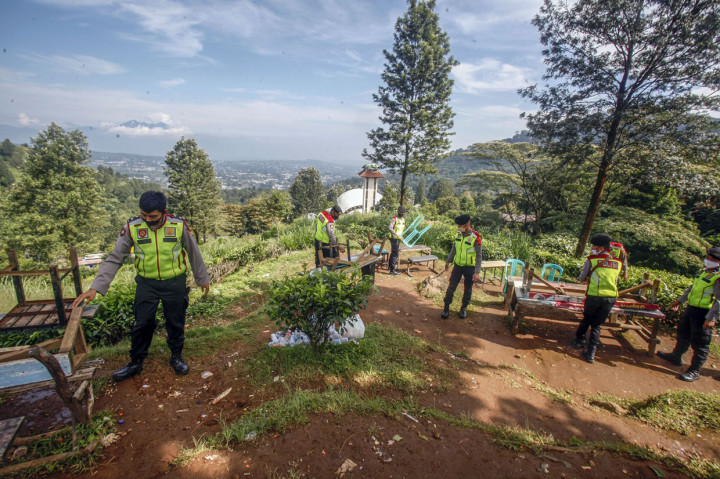 Sejumlah petugas kepolisian menutup lapak pedagang kaki lima yang ada di kawasan wisata Puncak di Kabupaten Bogor, Jawa Barat.
