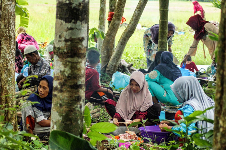 Masyarakat petani dengan latar belakang area persawahan, memasak makanan saat kenduri blang (kenduri turun kesawah) di Desa Paya, Simpang Kramat, Aceh Utara, Aceh.