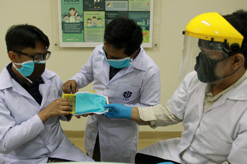 Tiga orang peneliti dari Lembaga Ilmu Pengetahuan Indonesia (LIPI) melakukan inovasi pembuatan masker kain disinfektor berbahan tembaga dengan teknik lapisan atau coating di Lab Fisika LIPI Serpong, Tangerang Selatan, Banten.
