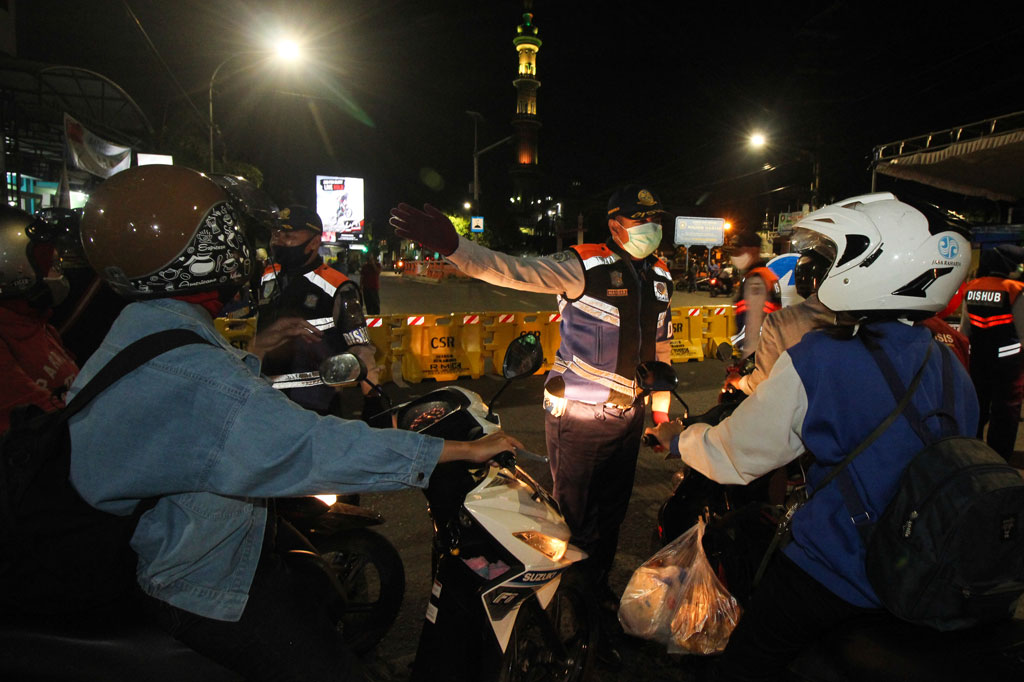 Petugas meminta pengendara kendaraan bermotor untuk berputar balik di Jalan Rungkut Menanggal, Surabaya, Jawa Timur, Kamis, 4 Juni 2020. Jalan penghubung Kota Surabaya-Sidoarjo itu ditutup sementara untuk menekan penyebaran covid-19.