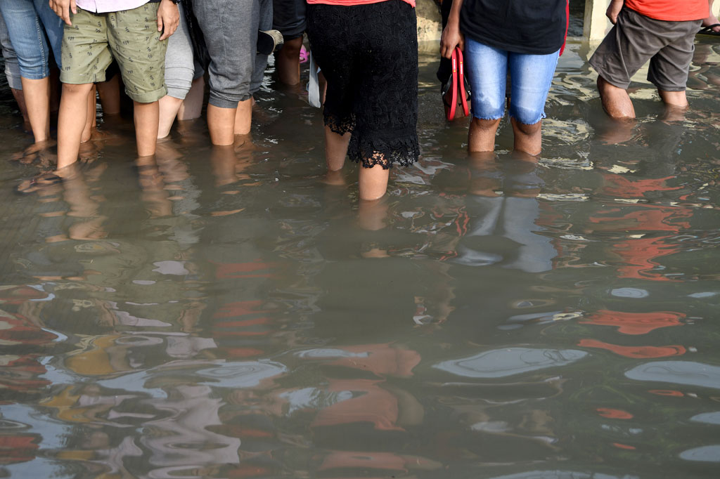 Warga melintasi banjir air rob di kawasan Muara Baru, Penjaringan, Jakarta Utara, Jumat, 5 Juni 2020. Belasan RW di wilayah pesisir Jakarta Utara terendam banjir air rob, mulai Kamis, 4 Juni 2020.