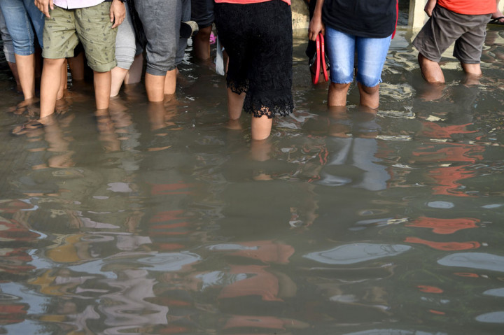 Warga melintasi banjir air rob di kawasan Muara Baru, Penjaringan, Jakarta Utara, Jumat, 5 Juni 2020. Belasan RW di wilayah pesisir Jakarta Utara terendam banjir air rob, mulai Kamis, 4 Juni 2020.