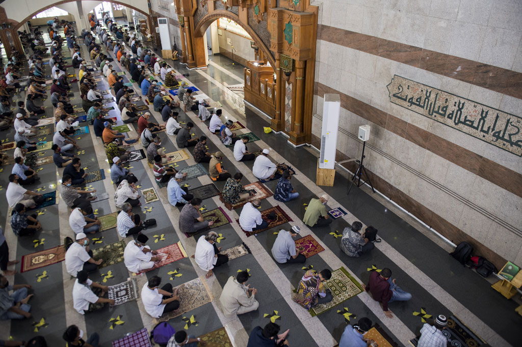 Umat Muslim menjaga jarak saat mendengarkan khutbah Salat Jumat di Masjid Pusdai, Bandung, Jawa Barat, Jumat, 5 Juni 2020