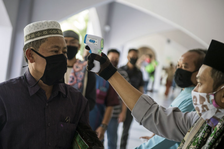 Setiap  jemaah yang memasuki masjid untuk menunaikan salat Jumat, suhu tubuhnya dicek dan tubuhnya disemprot disinfektan oleh pengurus masjid.