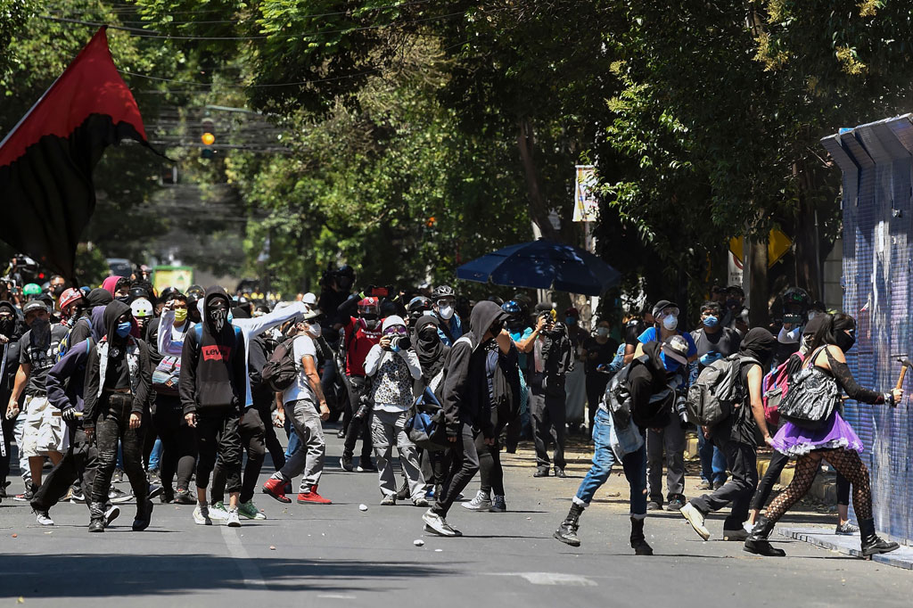 Para pria dan wanita bermasker yang memprotes kekerasan yang dilakukan polisi, merusak gedung-gedung dan melemparkan batu-batu di Kedutaan Besar Amerika Serikat (AS) di Mexico City pada Jumat, 5 Juni 2020 waktu setempat.