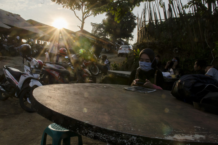 Pengunjung bersantai di salah satu saung kawasan wisata Caringin Tilu, Kabupaten Bandung Jawa Barat.