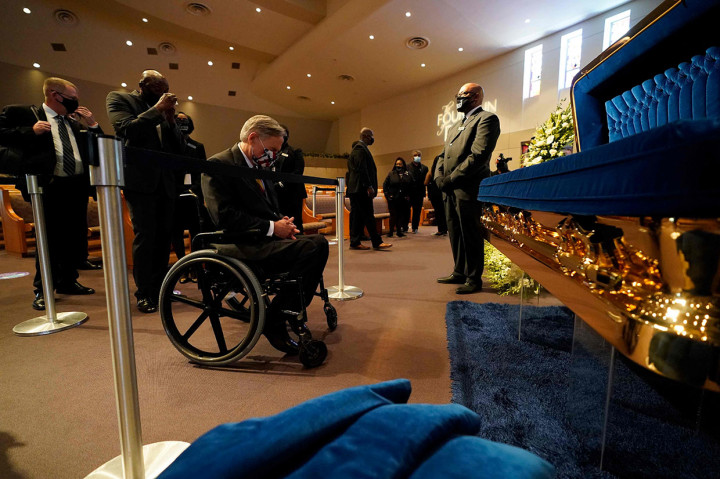 Di antara pelayat, hadir Gubernur Texas Greg Abbott. Abot yang menggunakan kursi roda berdoa sejenak di depan mati Floyd.