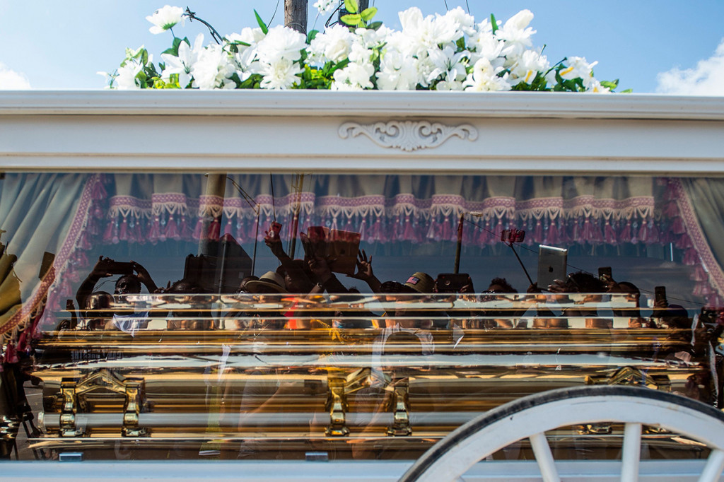 Warga melambaikan tangan sembari menitikkan air mata duka saat melepas kepergian George Floyd ke peristirahatan terakhir.