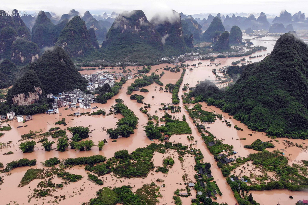 Foto yang diambil pada 7 Juni 2020 menunjukkan jalan dan bangunan yang terendam setelah hujan deras menyebabkan banjir di Yangshuo, wilayah selatan Guangxi, Tiongkok.