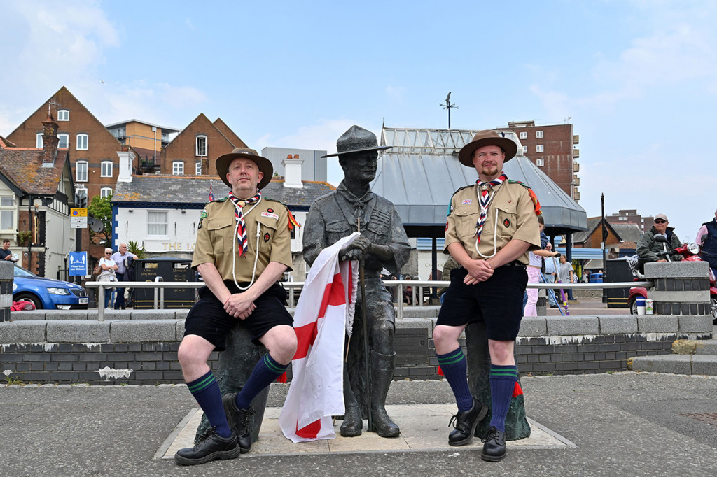 Dua warga lokal berpakaian pramuka berfoto bersama patung pendiri Kepanduan, Robert Baden-Powell di dermaga di Bournemouth, Inggris, Kamis, 11 Juni 2020 waktu setempat.
