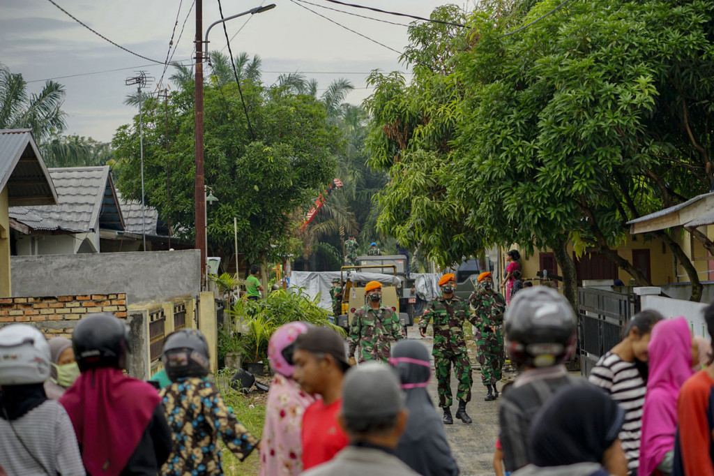 Sejumlah warga melihat proses evakuasi bangkai pesawat tempur TNI AU yang jatuh di pemukiman warga di Desa Kubang Jaya, Kabupaten Kampar, Riau.
