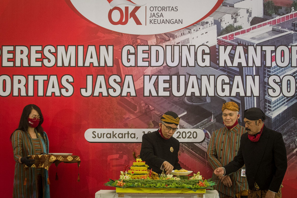 Ketua Dewan Komisioner Otoritas Jasa Keuangan (OJK) Wimboh Santoso (kedua kiri) memotong nasi tumpeng didampingi Wali Kota Solo FX Hadi Rudyatmo (kanan) dan Kepala OJK Solo Eko Yunianto, saat meresmikan kantor baru OJK Solo di Jalan Slamet Riyadi, Solo, Jawa Tengah, Jumat, 19 Juni 2020. 
