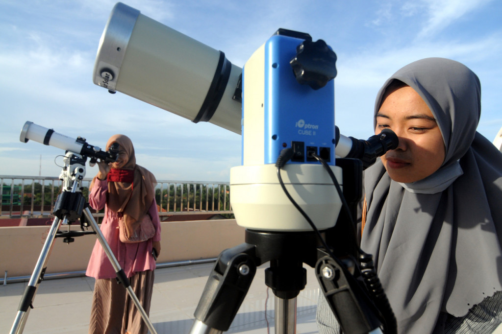 Mahasiswi mengamati matahari saat terjadi gerhana sebagian di Observatorium Jokotole IAIN Madura, Pamekasan, Jawa Timur. ANTARA Foto/Saiful Bahri