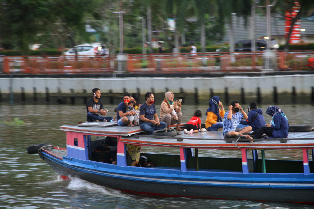 Sejumlah warga menaiki kelotok (perahu bermesin) tanpa jaga jarak saat susur sungai Martapura di kawasan wisata Menara Pandang Siring Sungai Martapura Banjarmasin, Kalimantan Selatan.