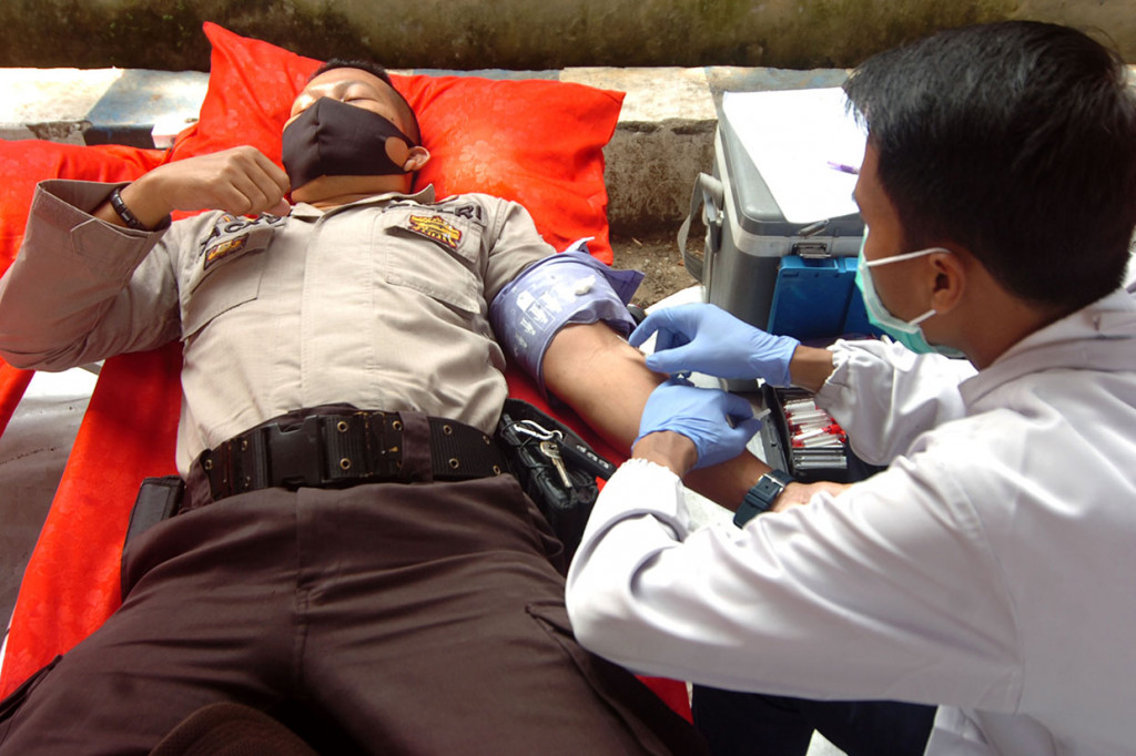 Personel polisi diambil darahnya saat donor darah dan tes diagnostik cepat (rapid test) Covid-19 di Polres Brebes, Jawa Tengah.