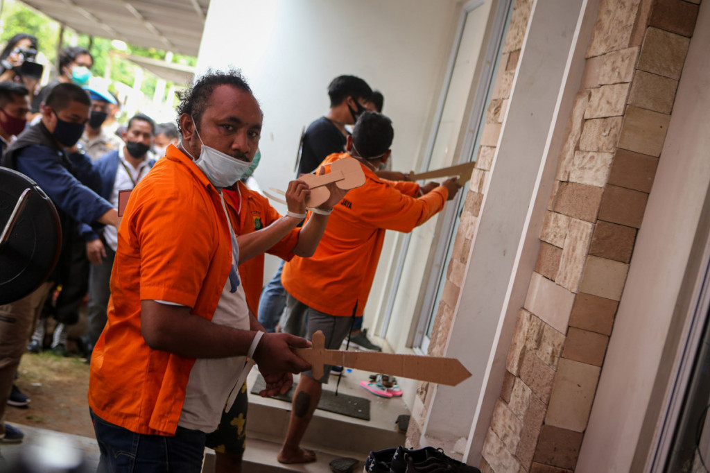 Tersangka yang juga anak buah John Kei memperagakan reka ulang penyerangan di Perumahan Green Lake City, Kota Tangerang, Banten.
