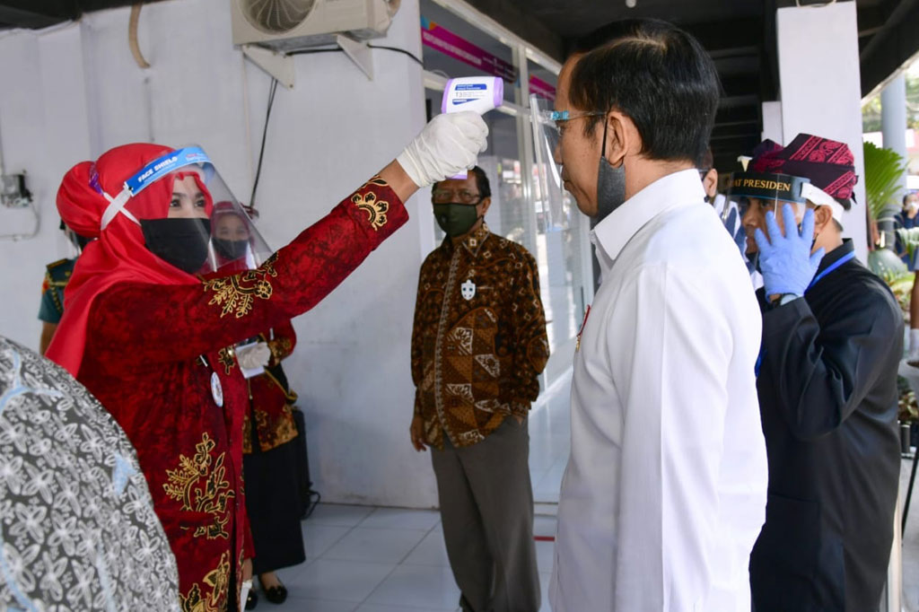 Presiden Joko Widodo diukur suhu tubuhnya saat meninjau Pasar Pelayanan Publik di Kecamatan Rogojampi, Kabupaten Banyuwangi, Jawa Timur, Kamis, 25 Juni 2020.