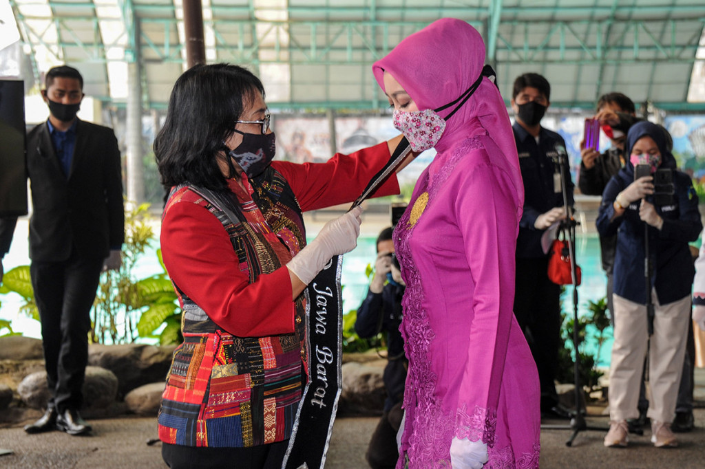 Menteri Pemberdayaan Perempuan dan Perlindungan Anak Bintang Puspayoga (kiri) menyematkan selempang pada Ketua Tim Penggerak PKK Provinsi Jawa Barat Atalia Praratya Kamil sebagai tanda dikukuhkannya menjadi Bunda Forum Anak Daerah di Bandung, Jawa Barat, Jumat, 26 Juni 2020.