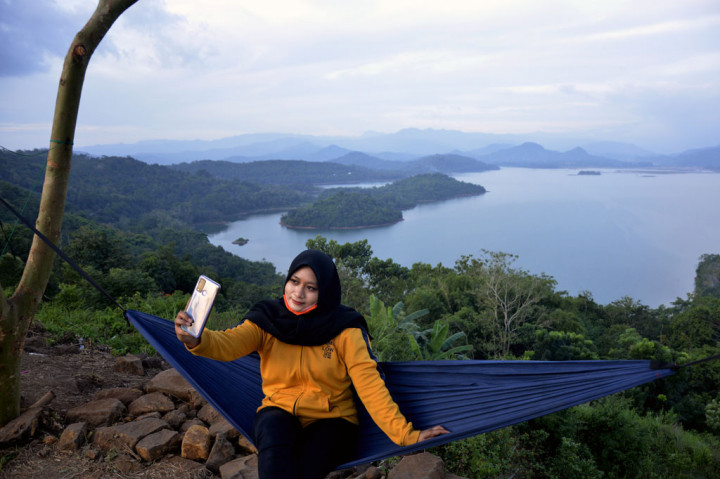 Pengunjung berfoto dengan latar suasana alam Bukit Indah Beroanging di Kecamatan Parangloe, Kabupaten Gowa, Sulawesi Selatan, Jumat, 26 Juni 2020. 