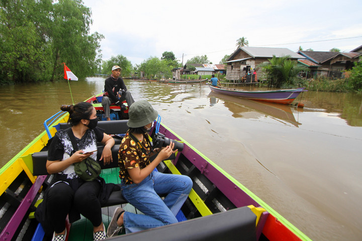 Wisatawan menikmati pemandangan saat wisata susur sungai di Hutan Mangrove Alami Kuin Kecil, Banjarmasin, Kalimantan Selatan.
