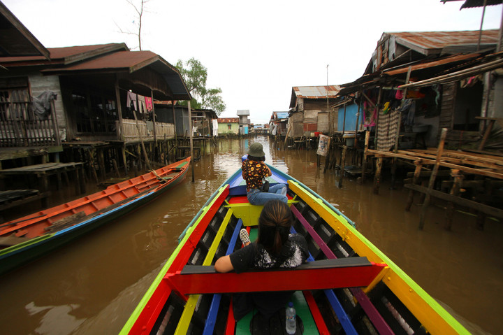 Wisatawan menikmati pemandangan rumah yang berada di bantaran anak sungai Martapura saat wisata susur sungai di Banjarmasin, Kalimantan Selatan.