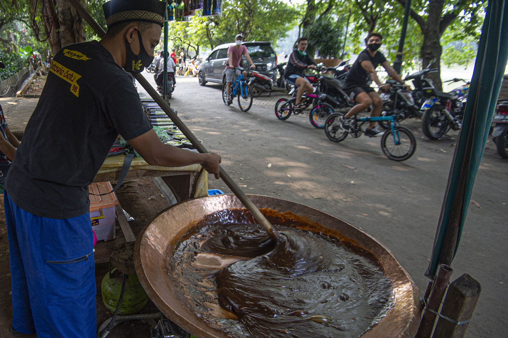 Perajin membuat makanan dodol betawi di tepi Waduk Setu Babakan, Jakarta.