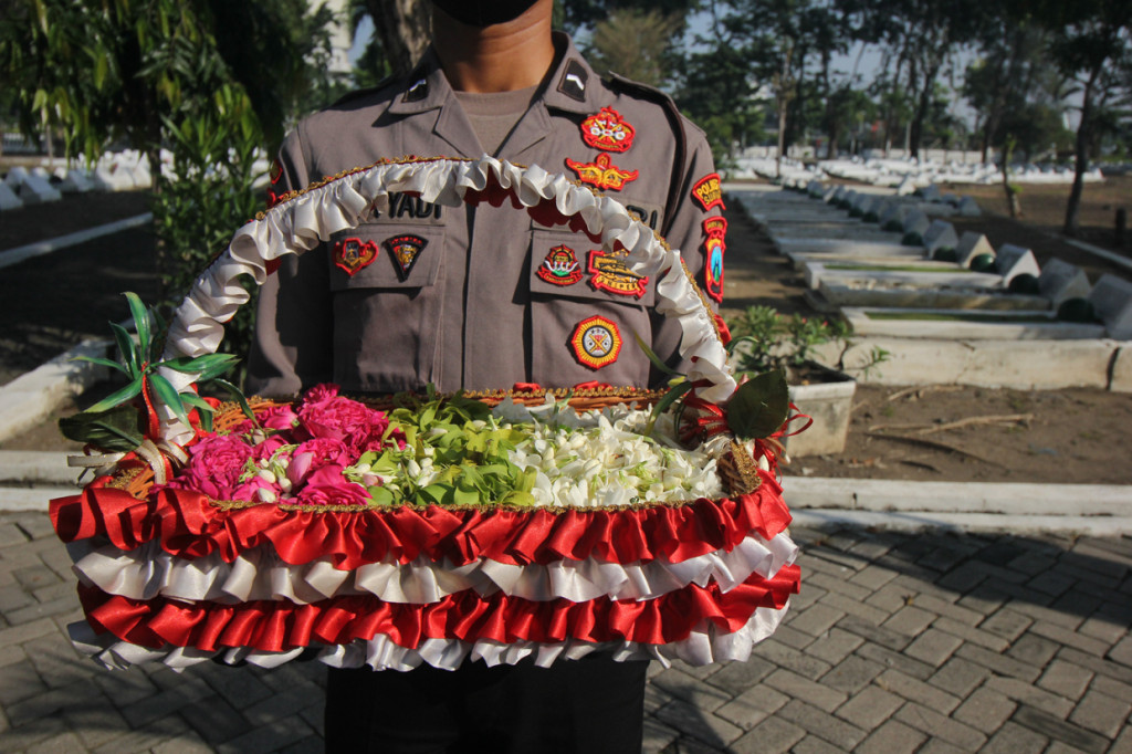 Anggota Polri bersiap menabur bunga di Taman Makam Pahlawan 10 November di Surabaya, Jawa Timur.