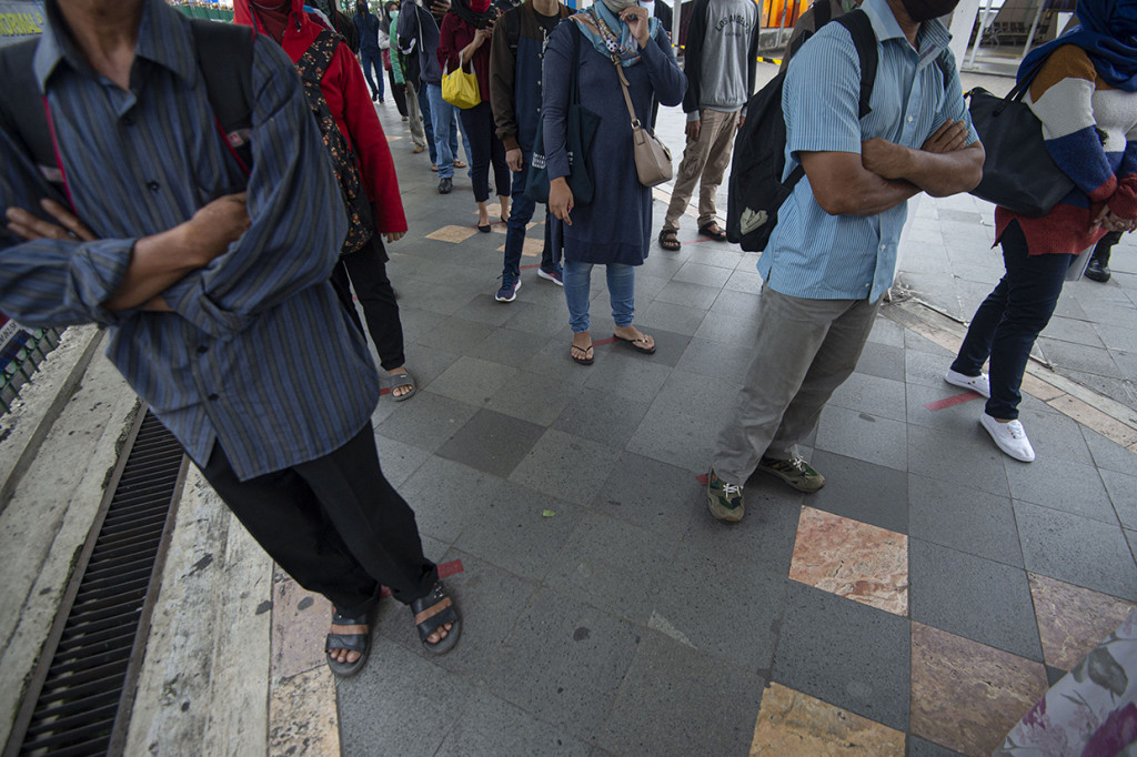 Pembatasan penumpang di dalam KRL maupun di area peron menyebabkan antrean panjang penumpang di stasiun tersebut. 