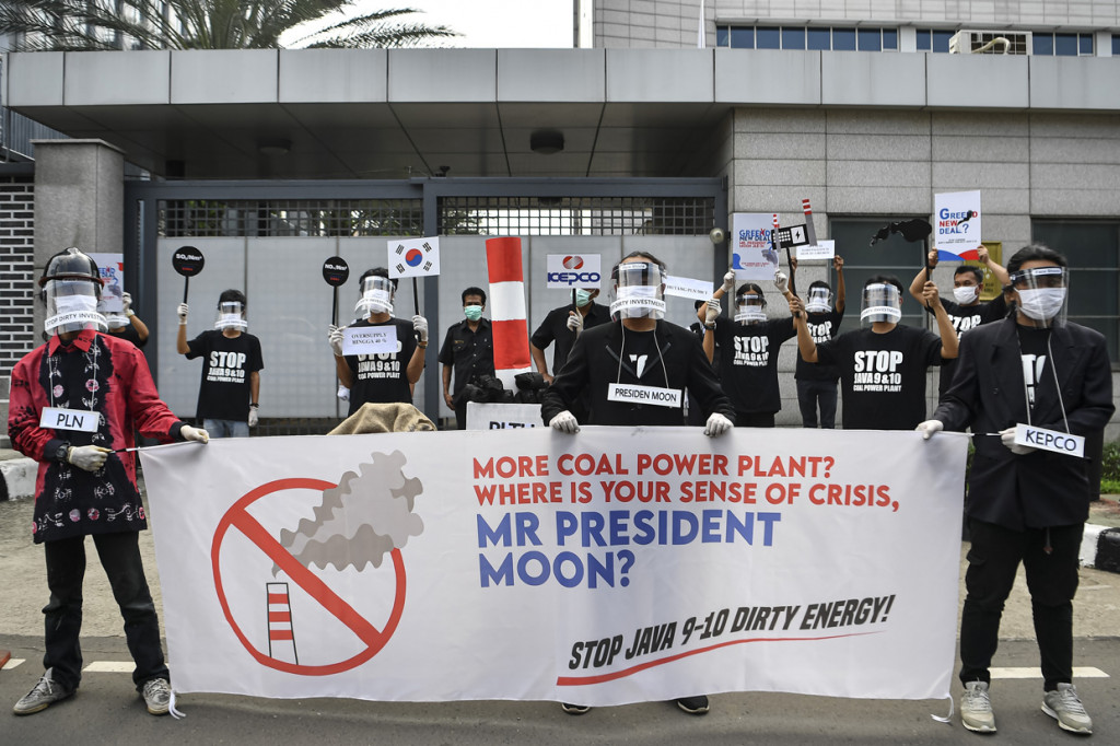Aktivis dari Koalisi Masyarakat Sipil Tolak PLTU membenangkan spanduk dan poster saat menggelar aksi penolakan mega proyek PLTU Jawa 9 dan 10 di depan Kedutaan Besar Korea Selatan, Jakarta.