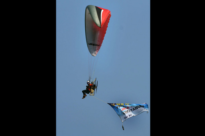 Anggota Federasi Aero Sport Indonesia (FASI) mensosialisasikan protokol kesehatan tatanan normal baru dengan paralayang saat acara Bakti Sosial Spotdirga (Staf Potensi Dirgantara) TNI AU di Pangkalan Detasemen TNI AU Gorda, Serang, Banten.