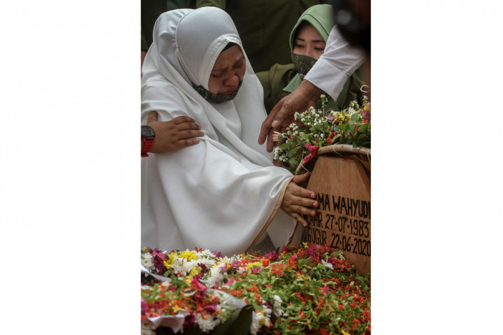 Istri dan ketiga anak almarhum tidak kuasa menahan tangis saat jenazah dimasukkan ke liang lahat.