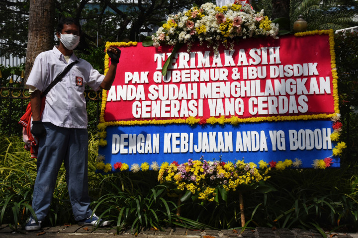 Agung wibowo hadi (46) selaku Relawan PPDB DKI Jakarta 2020 berswafoto di depan karangan bunga yang terpajang di depan pintu masuk Balai Kota Jakarta, Jalan Medan Merdeka Selatan, Jakarta Pusat.