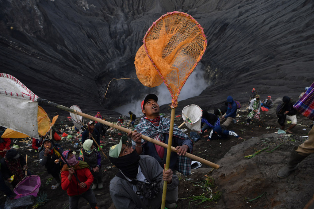 Warga berebut sesaji yang dilempar oleh masyarakat Suku Tengger ke kawah Gunung Bromo dalam rangka perayaan Yadnya Kasada, Probolinggo, Jawa Timur. ANTARA Foto/Zabur Karuru