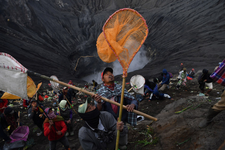 Warga berebut sesaji yang dilempar oleh masyarakat Suku Tengger ke kawah Gunung Bromo dalam rangka perayaan Yadnya Kasada, Probolinggo, Jawa Timur. ANTARA Foto/Zabur Karuru