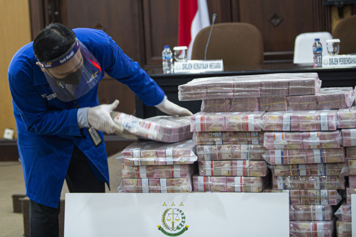 Petugas menata barang bukti berupa uang sitaan di kantor Kejaksaan Agung (Kejagung), Jakarta.
