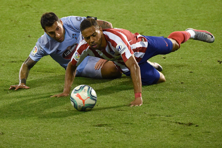 Pemain belakang Atletico Renan Lodi jatuh bangun saat mempertahankan bola dari sergapan pemain bertahan Vigo, Hugo Mello. Skor 1-1 bertahan hingga laga usai