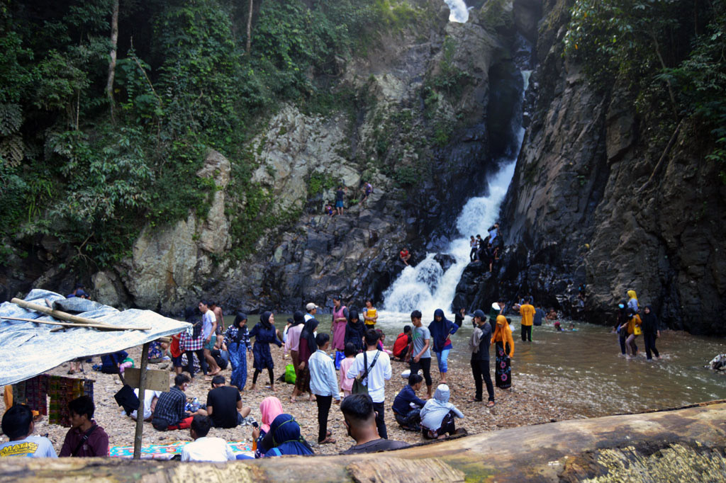 Wisatawan menikmati sejuknya curahan air dari air terjun (Curug) Dengdeng di Desa Leuwibatu, Kecamatan Rumpin, Kabupaten Bogor, Jawa Barat.