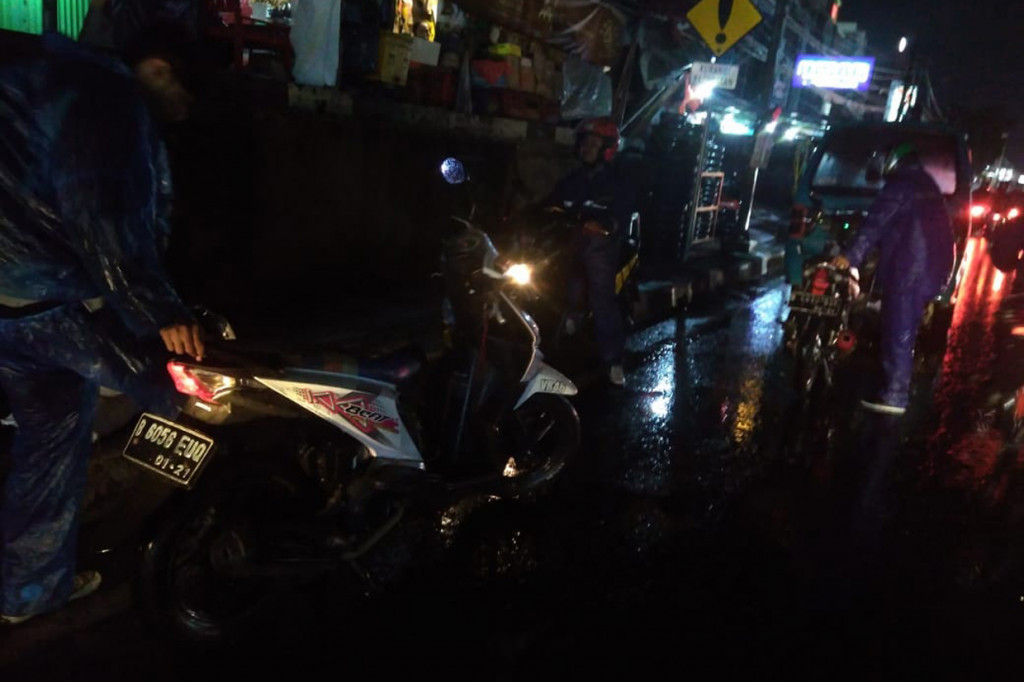 Banyak kendaraan roda dua yang nekat menerobos genangan mogok di tengah jalan.