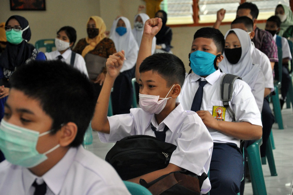 Sejumlah siswa baru yang didampingi orangtuanya mengikuti masa pengenalan lingkungan sekolah (MPLS) di SMP Negeri 1 Medan, Sumatera Utara, Kamis, 9 Juli 2020. 