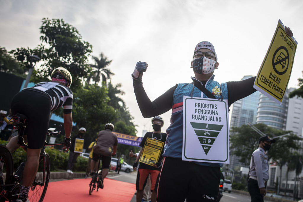 Anggota komunitas Bike to Work (B2W) Indonesia memegang poster saat melakukan aksi simpatik bertajuk Yang Bersepeda Yang Istimewa di Jalan Jenderal Sudirman, Senayan, Jakarta.